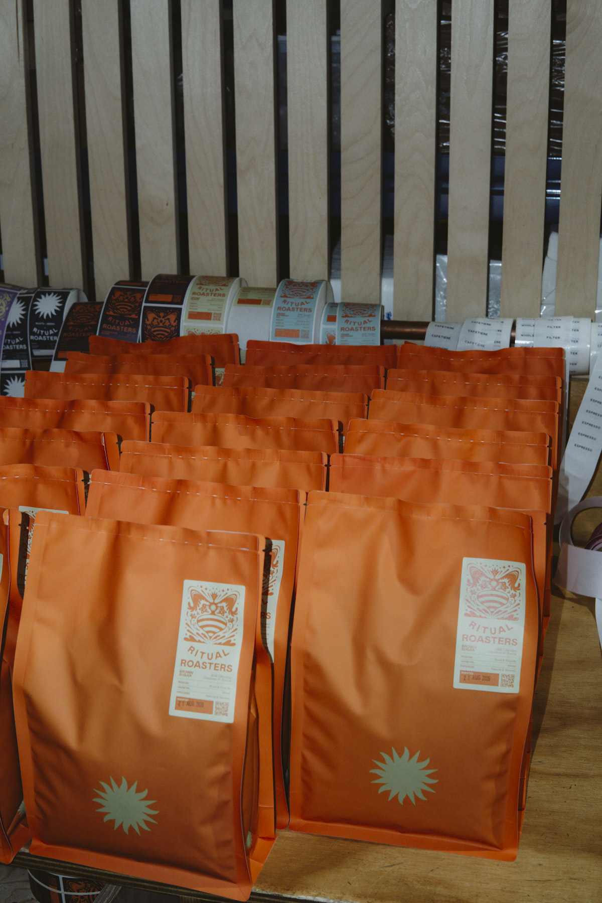 Rows of orange Ritual Coffee Roasters bags waiting to be labelled