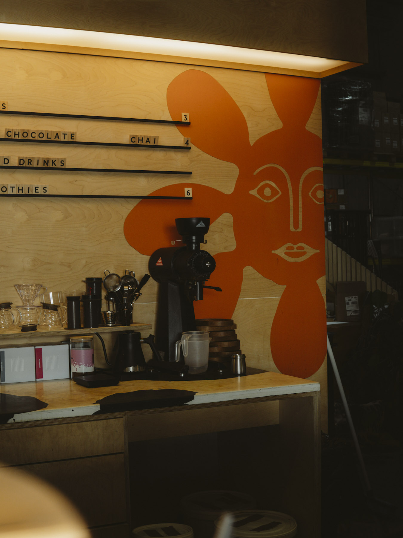 Espresso grinder in front of an orange sun face mural at Ritual Coffee Roasters